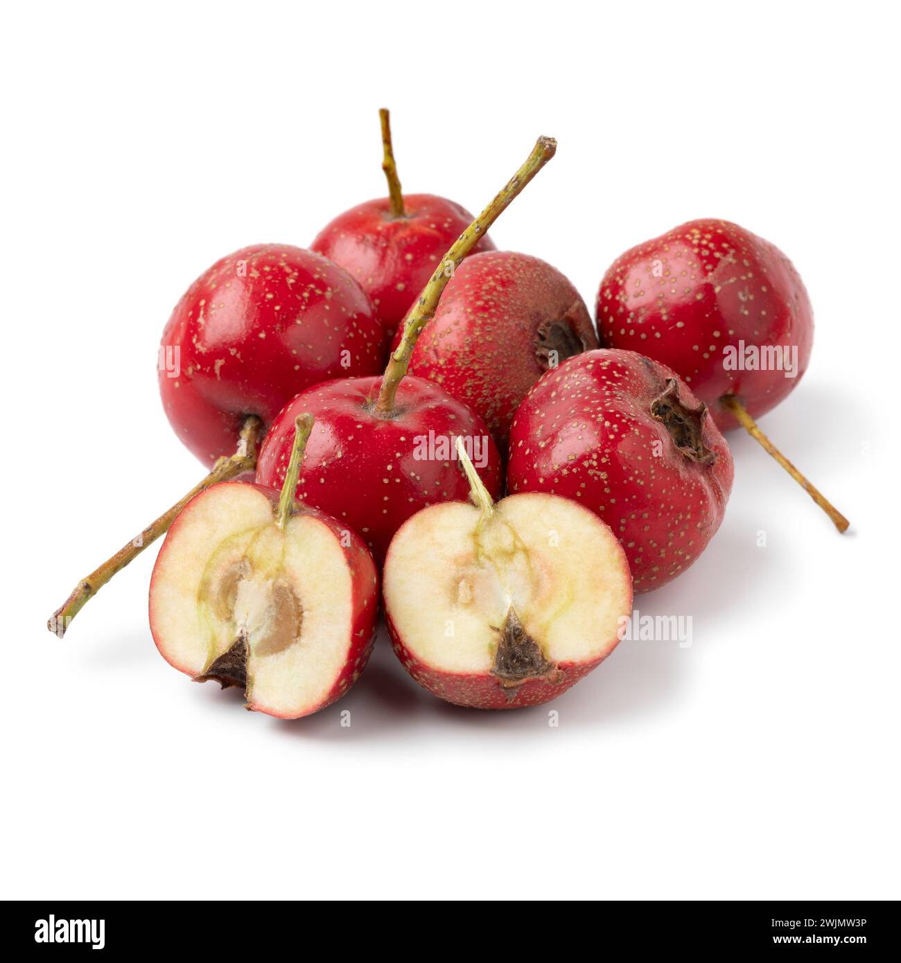Heap of whole and halved ripe fresh red hawthorne berry close up isolated on white background Stock Photo