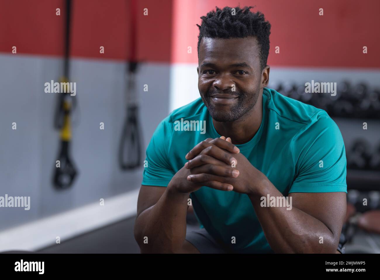 A fit African American man smiles during a gym workout Stock Photo