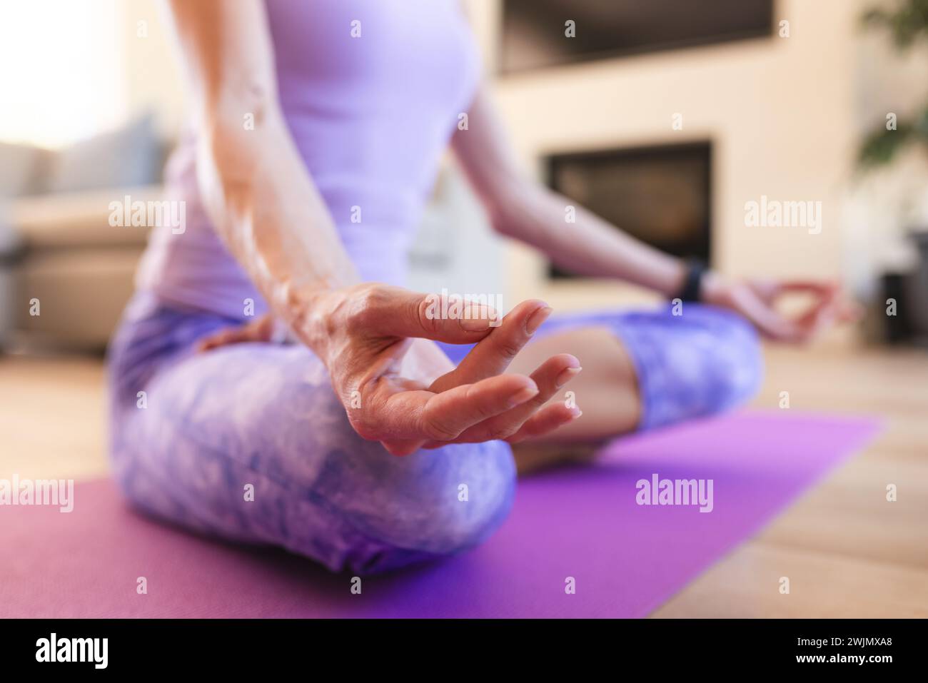 Caucasian middle-aged woman practices yoga at home, with copy space Stock Photo