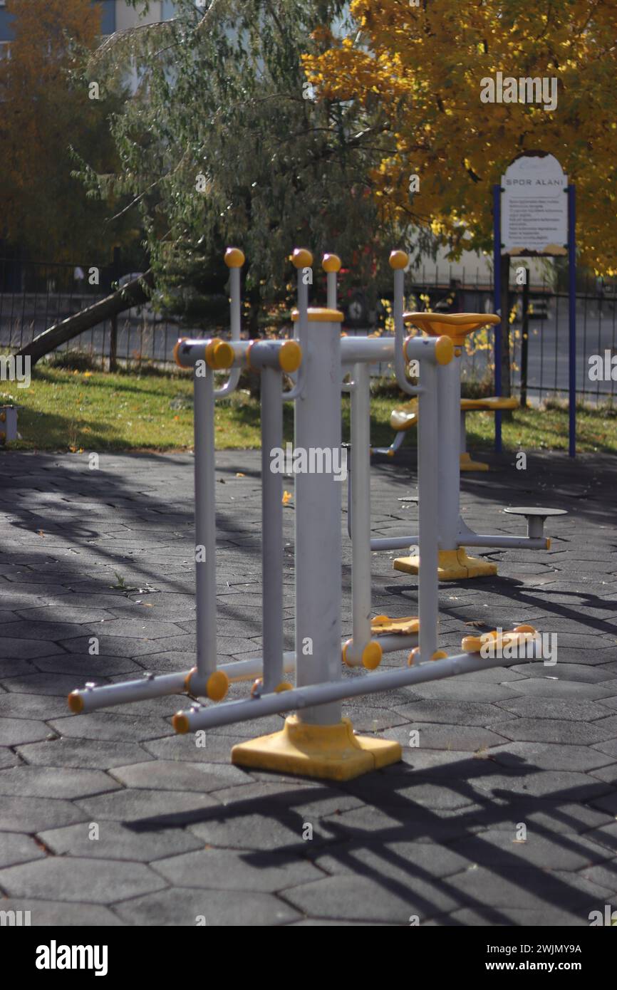 Depicts a public park equipped with various outdoor gym equipment pieces, promoting a healthy lifestyle. Stock Photo