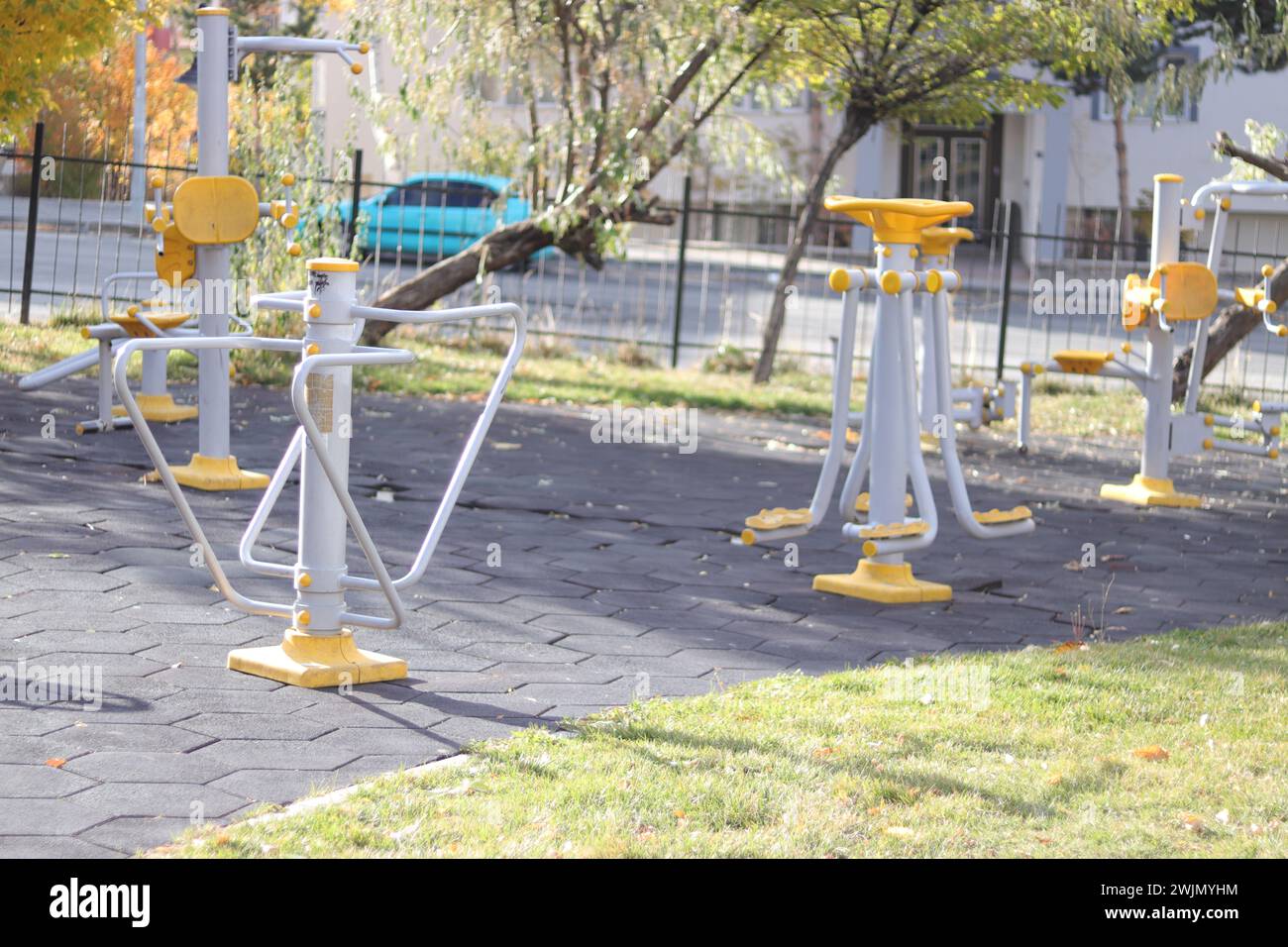 Depicts a public park equipped with various outdoor gym equipment pieces, promoting a healthy lifestyle. Stock Photo