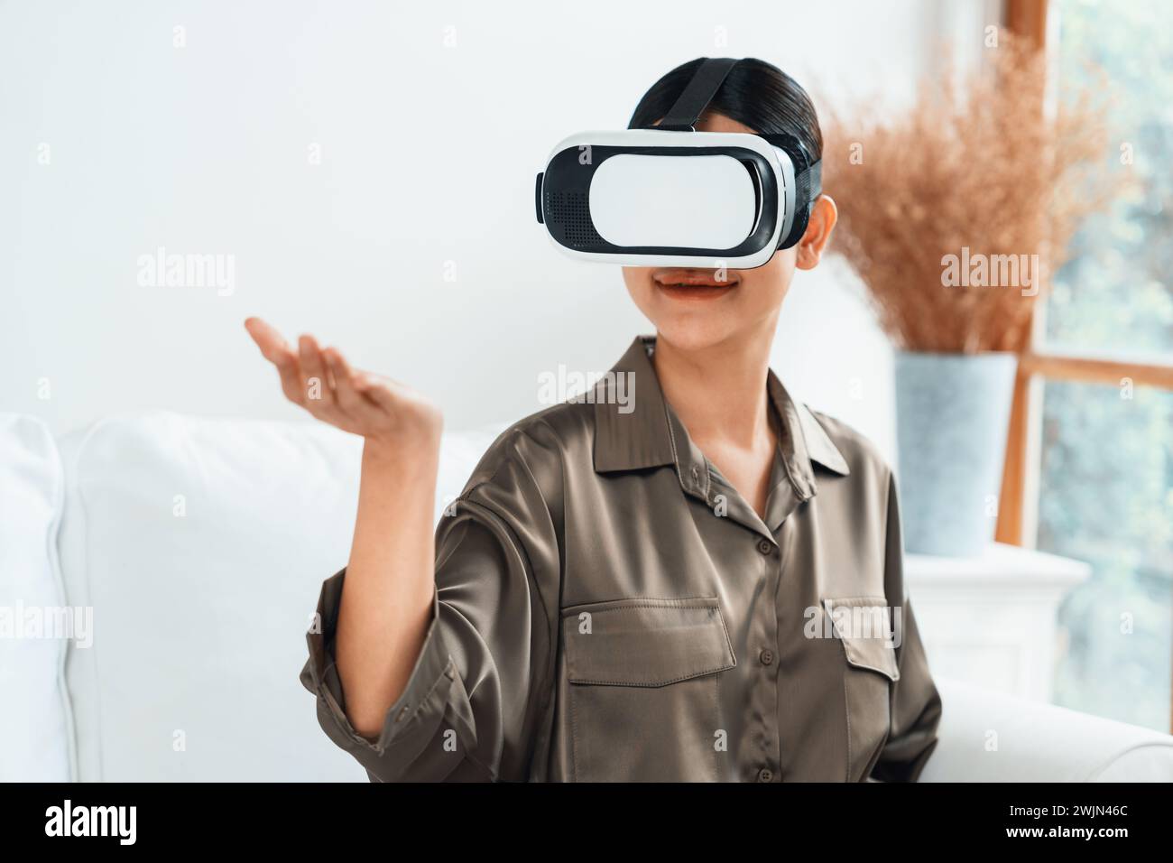 Young woman using virtual reality VR goggle at home for uttermost