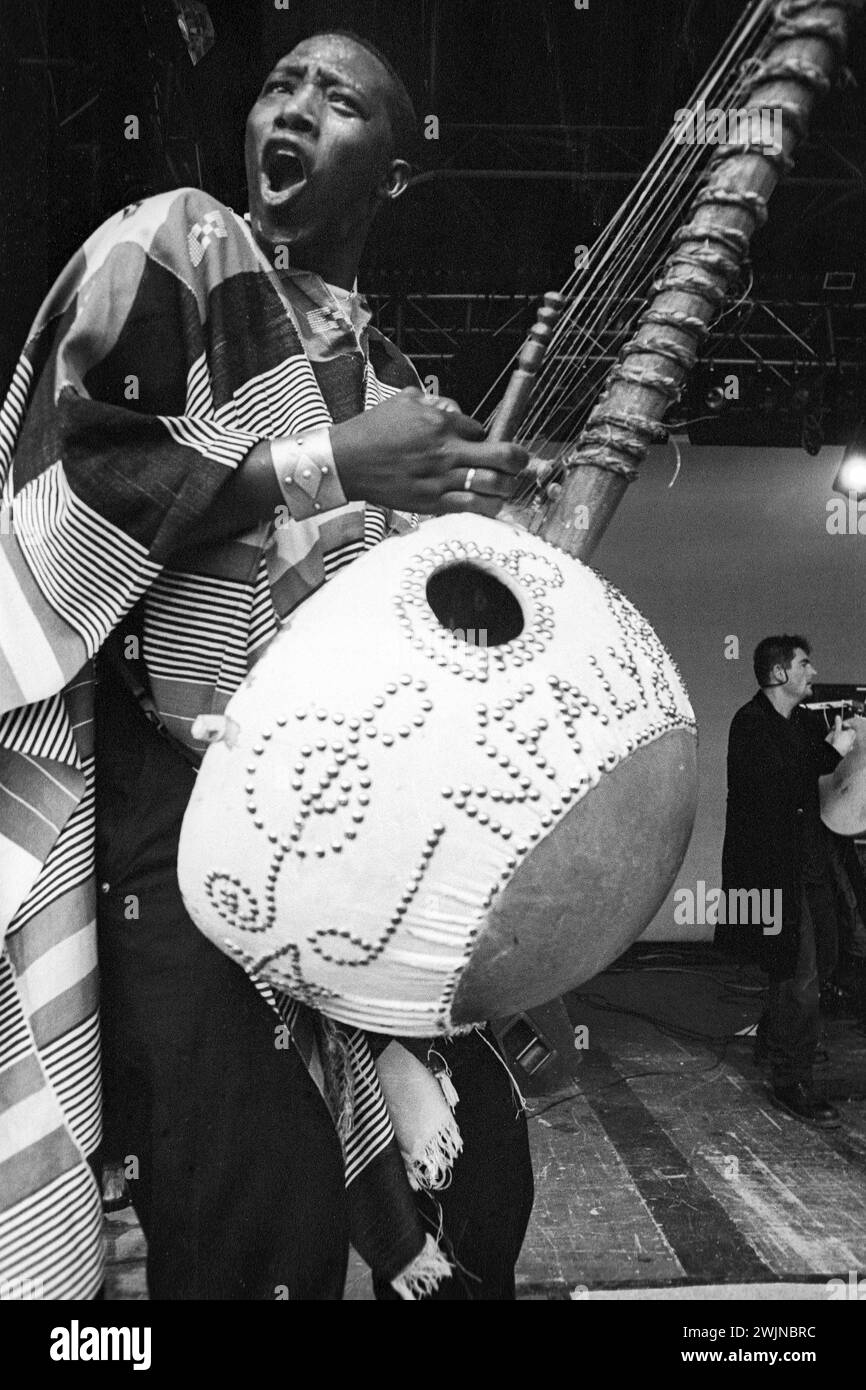 Afro Celt Sound System playing a giant Kora Instrument at Cardiff Big Weekend Festival on Museum Lawns in Cardiff, Wales, UK on 10 August 1997. Photo: Rob Watkins. INFO: Afro Celt Sound System, a pioneering group formed in the '90s, blended traditional African and Celtic music with electronic beats and global influences. Their exhilarating fusion, showcased in tracks like 'Release' and 'When You're Falling,' creates a transcendent musical journey that defies boundaries. Stock Photo