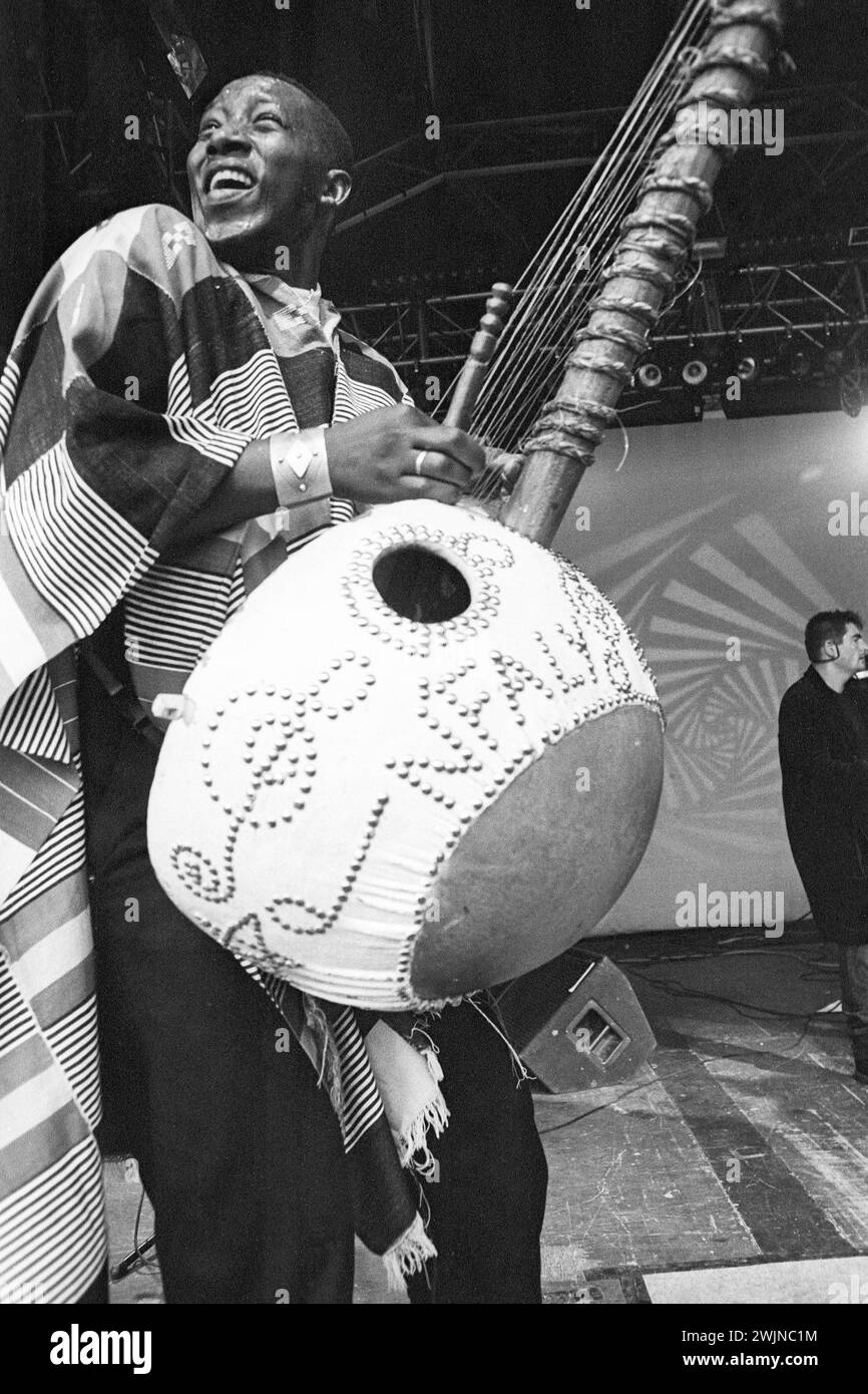 Afro Celt Sound System playing a giant Kora Instrument at Cardiff Big Weekend Festival on Museum Lawns in Cardiff, Wales, UK on 10 August 1997. Photo: Rob Watkins. INFO: Afro Celt Sound System, a pioneering group formed in the '90s, blended traditional African and Celtic music with electronic beats and global influences. Their exhilarating fusion, showcased in tracks like 'Release' and 'When You're Falling,' creates a transcendent musical journey that defies boundaries. Stock Photo