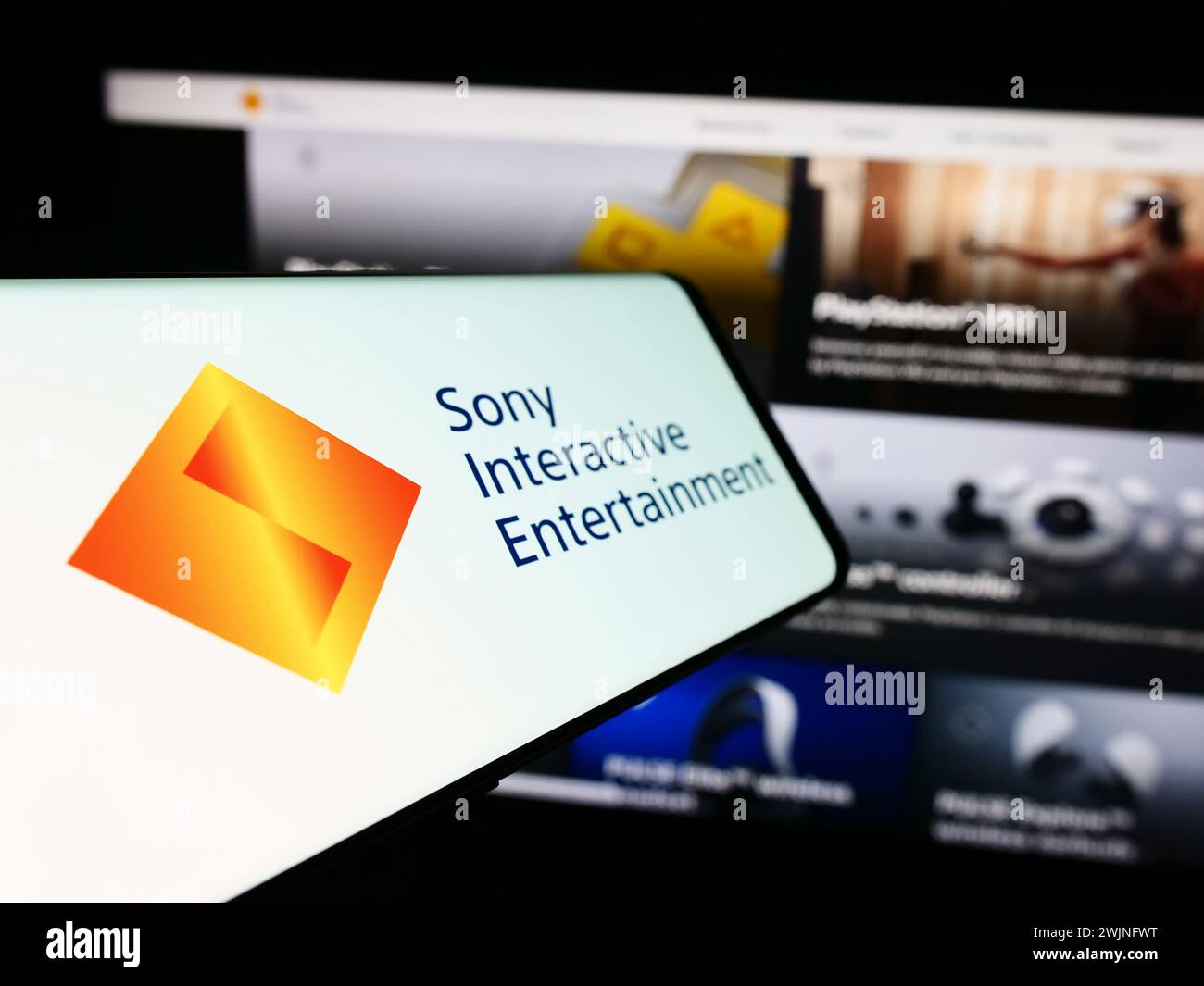 Smartphone with logo of US video game company Sony Interactive Entertainment LLC in front of website. Focus on center-left of phone display. Stock Photo