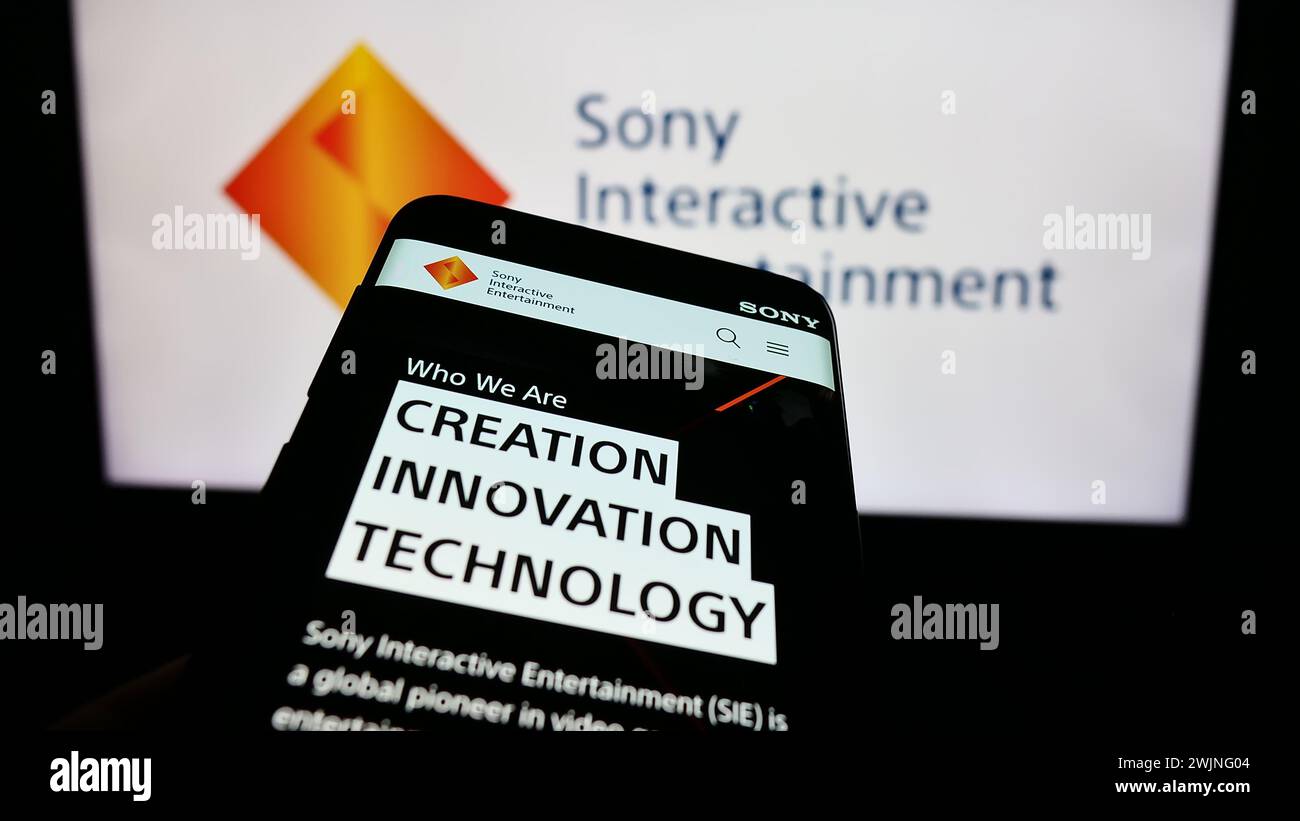 Mobile phone with website of US video game company Sony Interactive Entertainment LLC in front of logo. Focus on top-left of phone display. Stock Photo