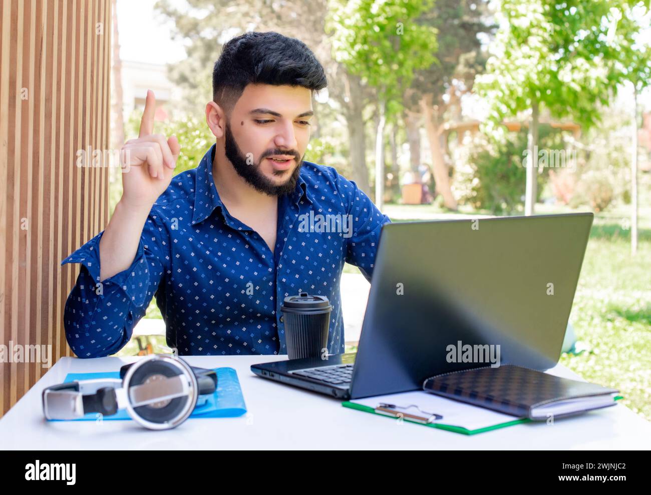 Businessman working at laptop, using webcam. Stock Photo