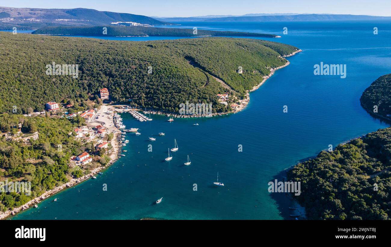 A breathtaking aerial perspective showcasing a serene lake, majestic mountains in Krnica village in southeastern Istria, Croatia Stock Photo