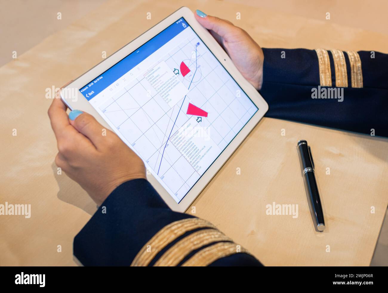 Unrecognizable female pilot preparing flight documentation on a tablet. Electronic flight bag. Selective focus. High quality photo. Stock Photo