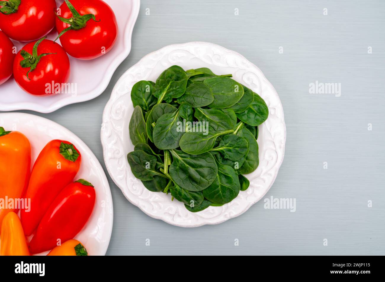 Fresh tomatoes, paprika, green spinach leaves, diet and health concept