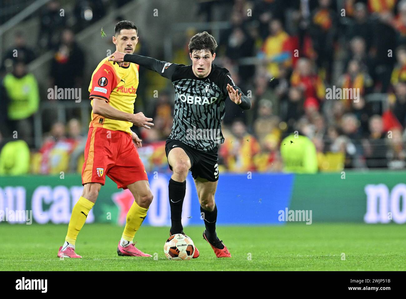 Lens, France. 15th Feb, 2024. Florian Sotoca (7) of RC Lens watching Merlin Röhl (34) of Freiburg during the Uefa Europa League play-off -first leg game in the 2023-2024 season between Racing Club de Lens and SC Freiburg on February 15, 2024 in Lens, France. (Photo by David Catry/Isosport) Credit: sportpix/Alamy Live News Stock Photo