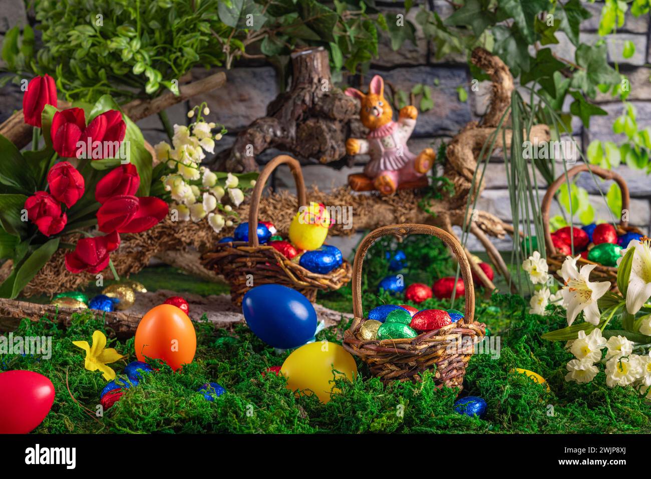 Easter basket with colourful eggs next to spring flowers and an Easter ...