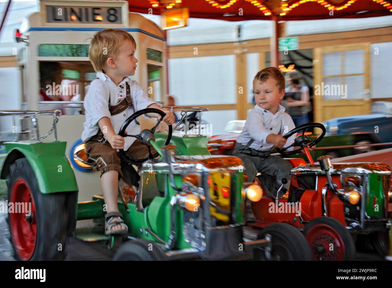 Boys on tractor in carousel, old, historic Oktoberfest, Oktoberfest, Munich, Upper Bavaria, Bavaria, Germany Stock Photo