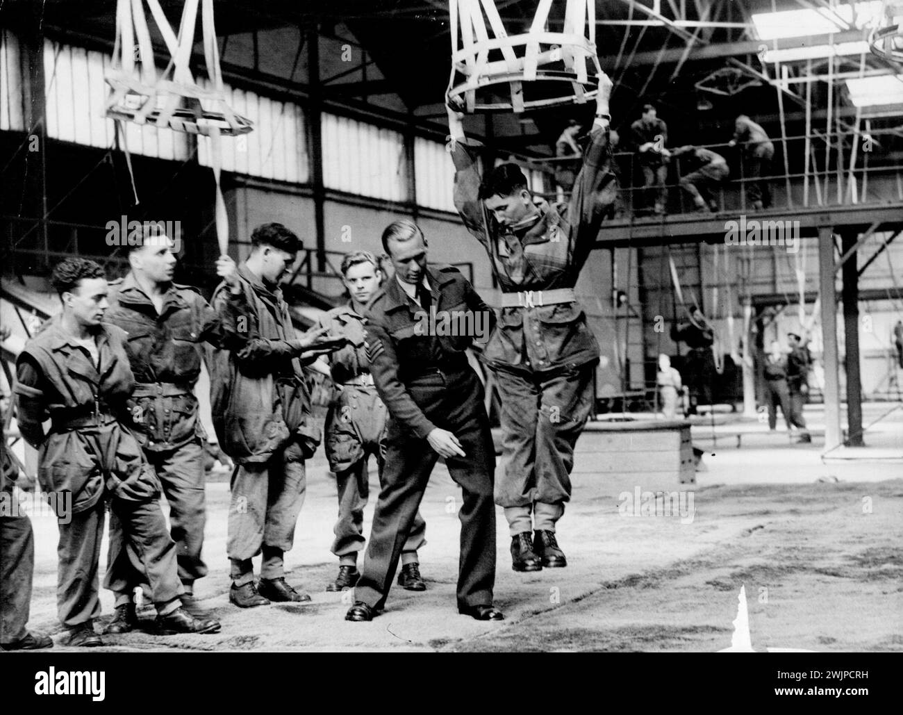 Paratroops in Training at the R.A.F. Parachute School, Upper Heyford, Oxfordshire.This R.A.F. Parachute training school, which trains all British airborne troops, has now completed 500,000 jumps. Since the school was formed in 1940 improve men's in technique and equipment have transformed what was originally regarded as a rather hazardous and frightening experience into something common place. During the peak years for the training of parachutists, 1943-45, the number of jumps at the school averaged about 110, 000 a year. Up to the end of 1945 three was one fatal accident in every 8,800 ju ... Stock Photo