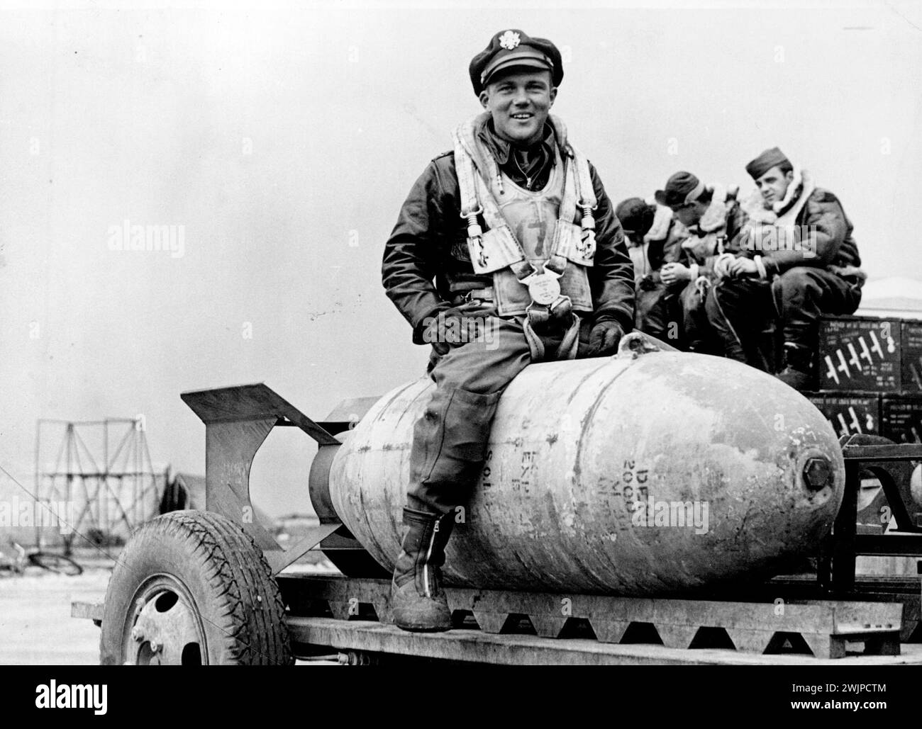 Defensive Power Of The Flying Fortresses. -- 2nd. Lt. Stanley R. Stedt of Stockholm, M.E., sitting on a 2,000lb, bomb. The entire defensive equipment of a Flying Fortress (not counting the weight of gunners, their oxygen supply, heating, clothing, etc.,) is more than 5,700 lbs. This immense weight of defensive armament necessary for successful between bomb loads for daylight or night operations. September 28, 1943. (Photo by London News Agency Photos). Stock Photo