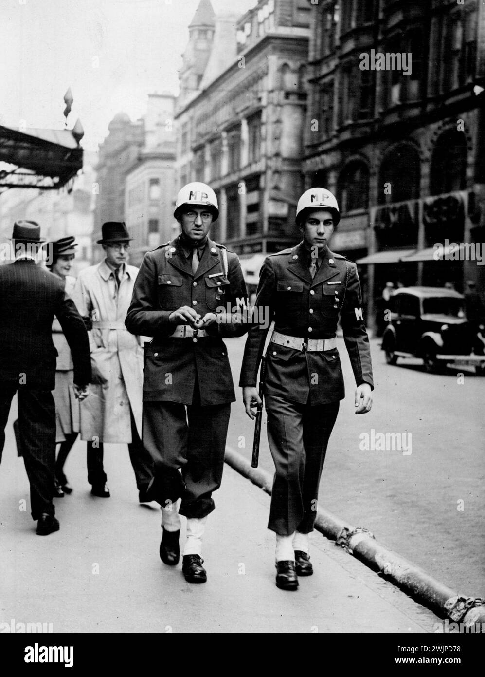 Birmingham In Wartime -- American Military Police, with white black out helmet, belt and anklets patrol New street. November 01, 1949. (Photo by Pictorial Press) Stock Photo