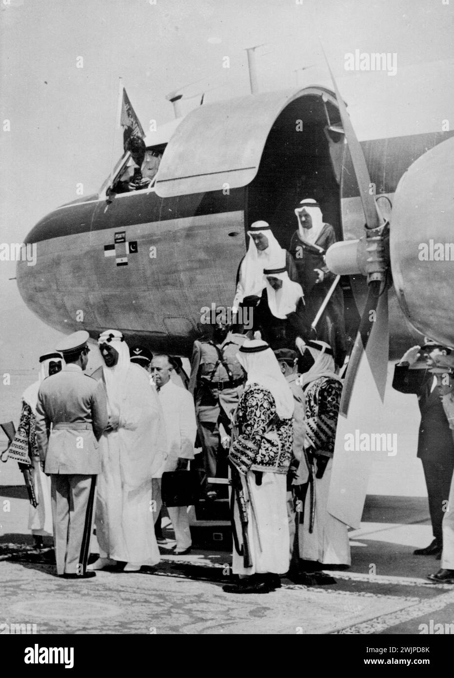 King Saud Visits Persia -- The Shah of Persia, Reza Pahlevi (back to camera) greets King Saud of Arabia on his arrival at Mehrabad airport, Teheran, on a three-day state visit to Persia. August 12, 1955. (Photo by United Press photo). Stock Photo