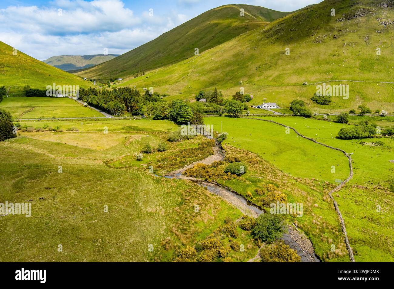 Aerial view of Joyce's river winding down below in Connemara region in Ireland. Scenic Irish countryside landscape with magnificent mountains on the h Stock Photo