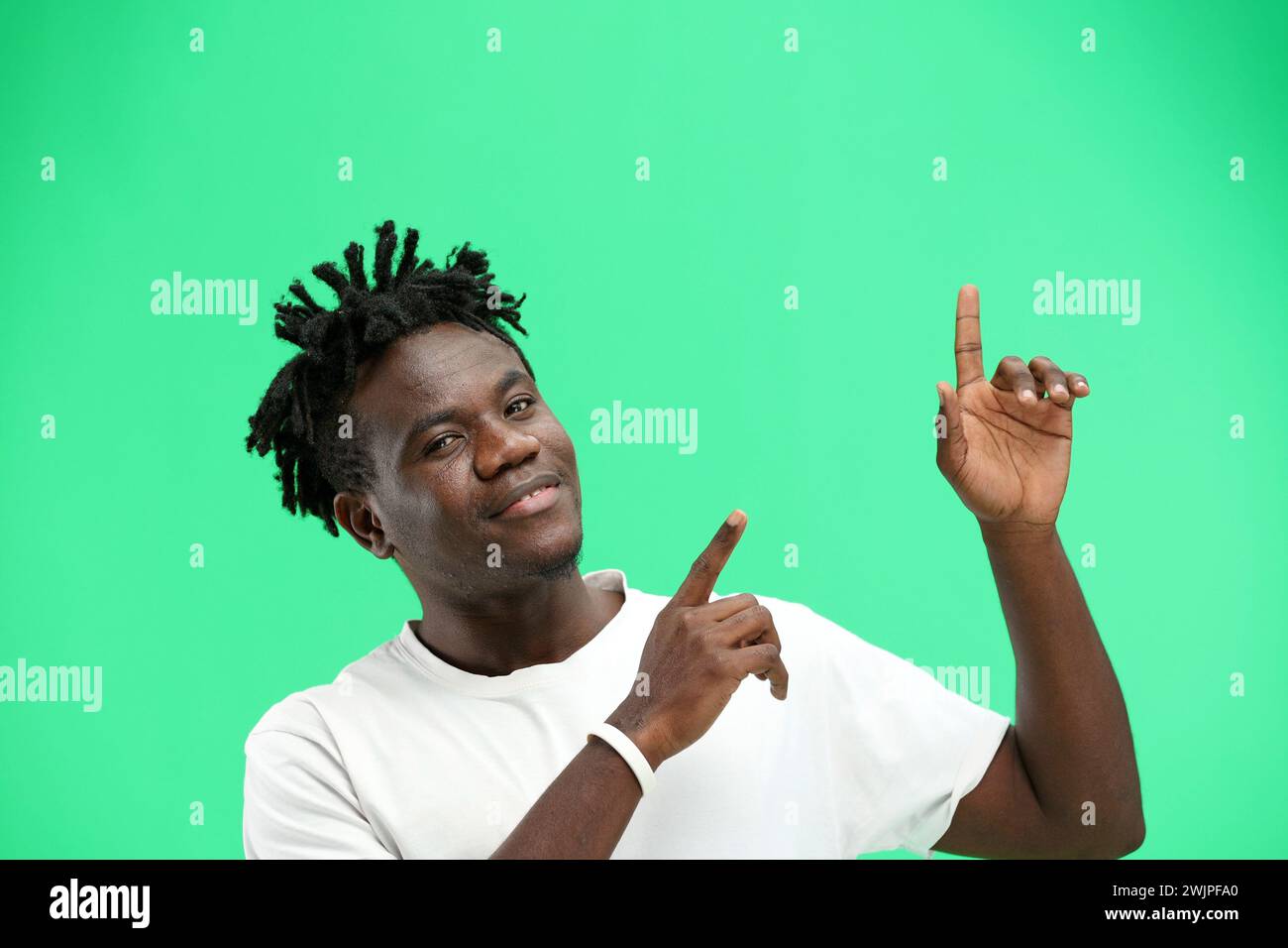 Man, close-up, on a green background, pointing up. Stock Photo