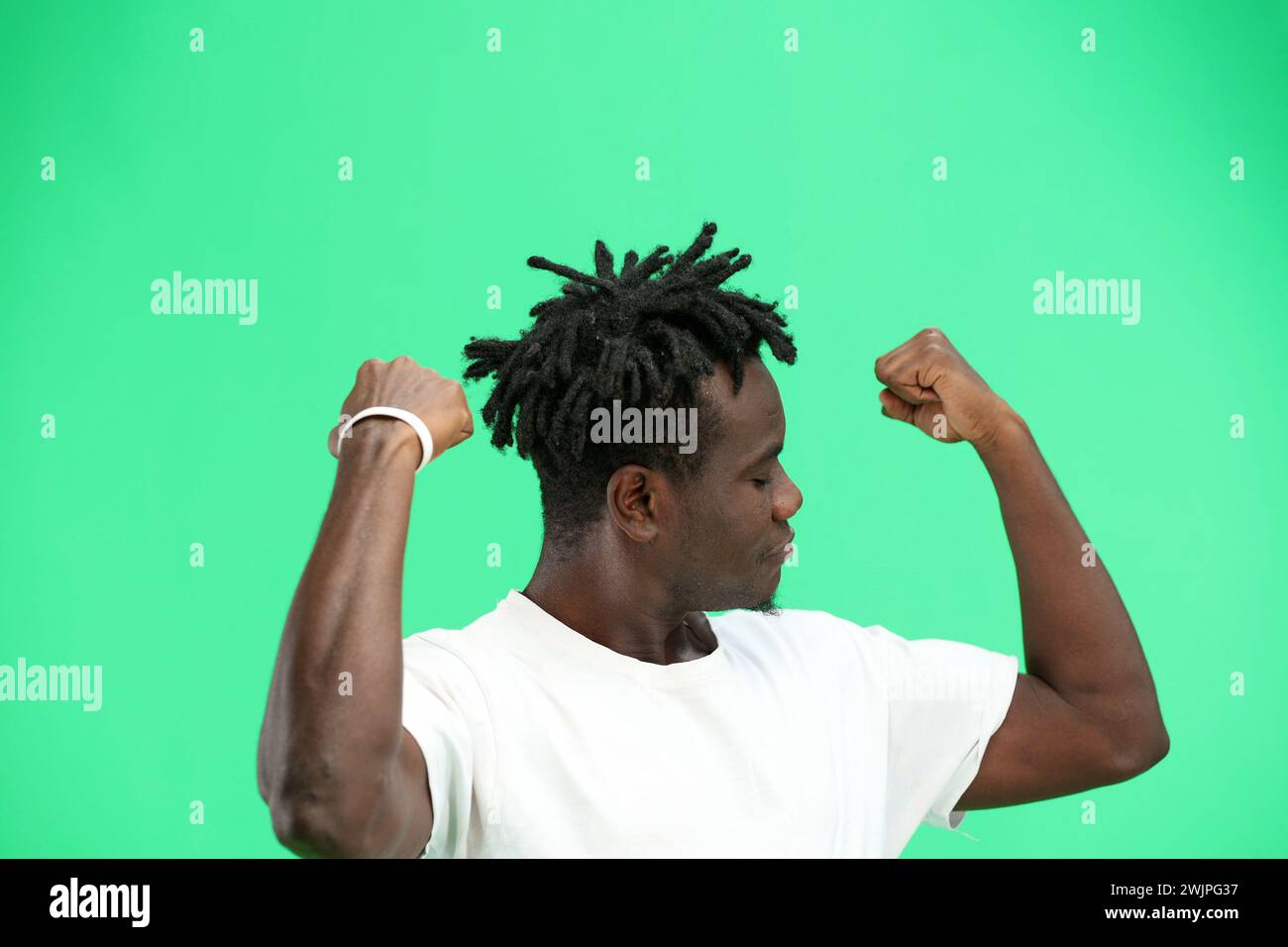 Man, close-up, on a green background, shows strength. Stock Photo