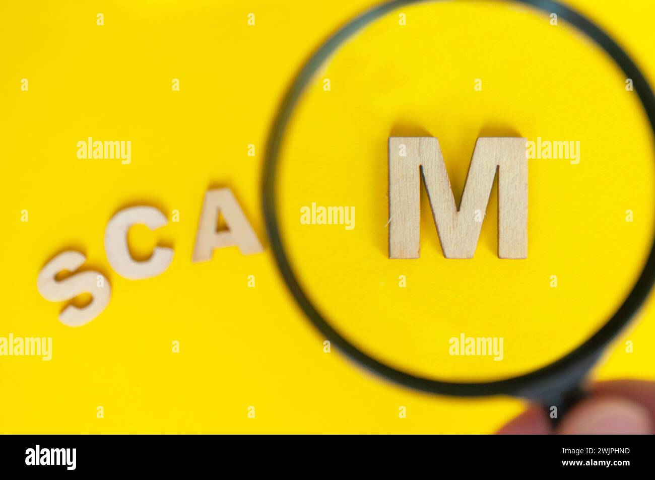 Top view of magnifying glass focusing on the work SCAM. Cyber crime concept. Stock Photo