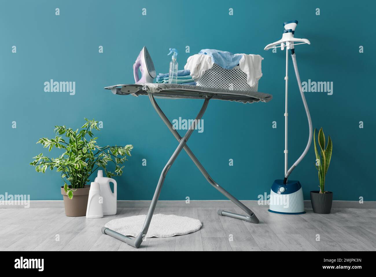 Interior of laundry room with ironing board and steamer Stock Photo - Alamy