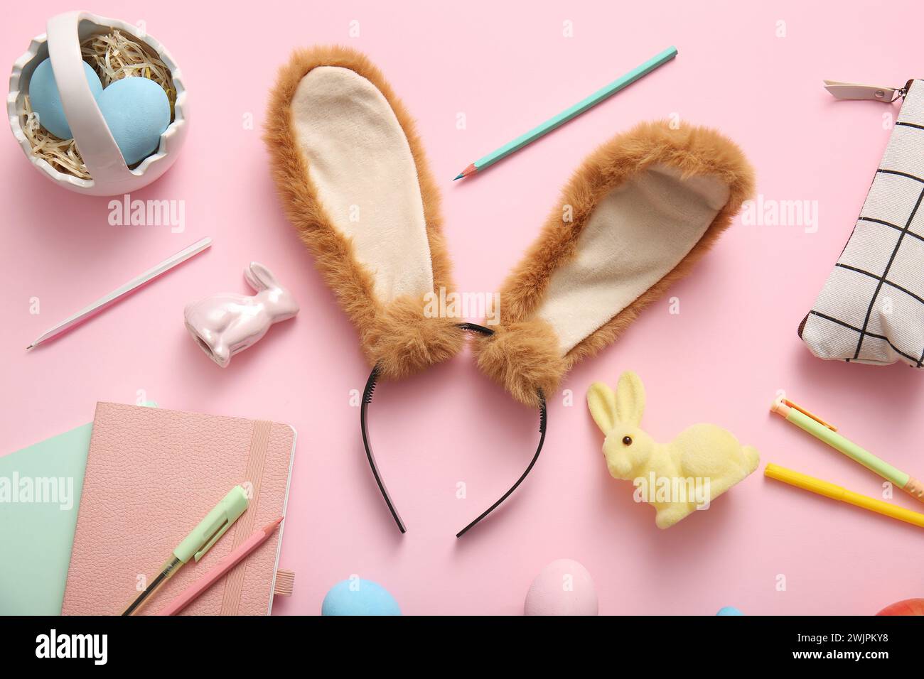 Bunny ears with Easter eggs and stationery on pink background Stock ...