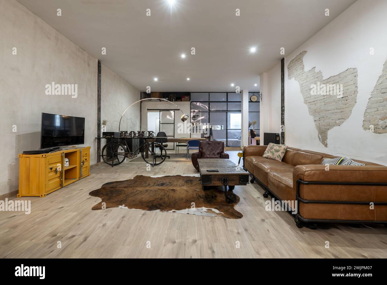 Large living room of a loft-type house with brown leather sofa ...