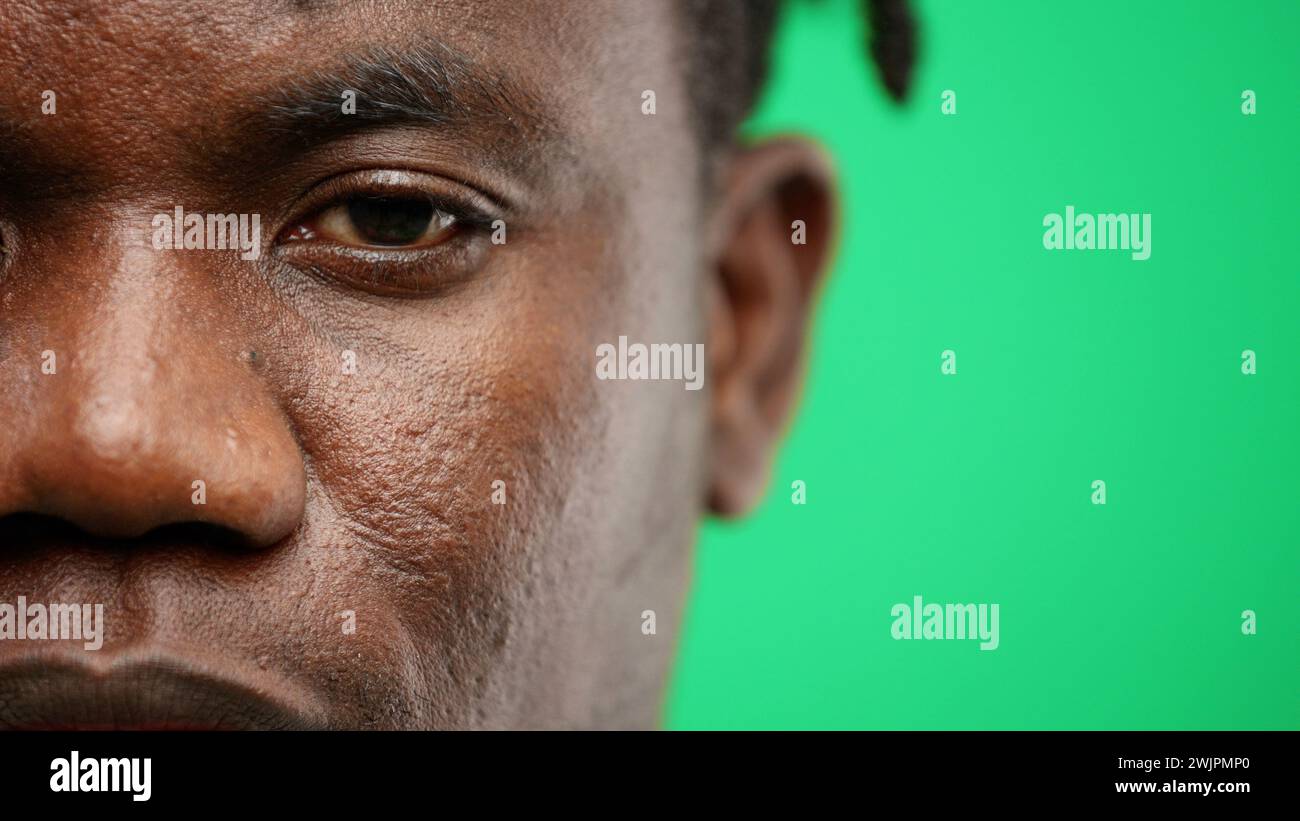 Man's face, close-up, on a green background. Stock Photo