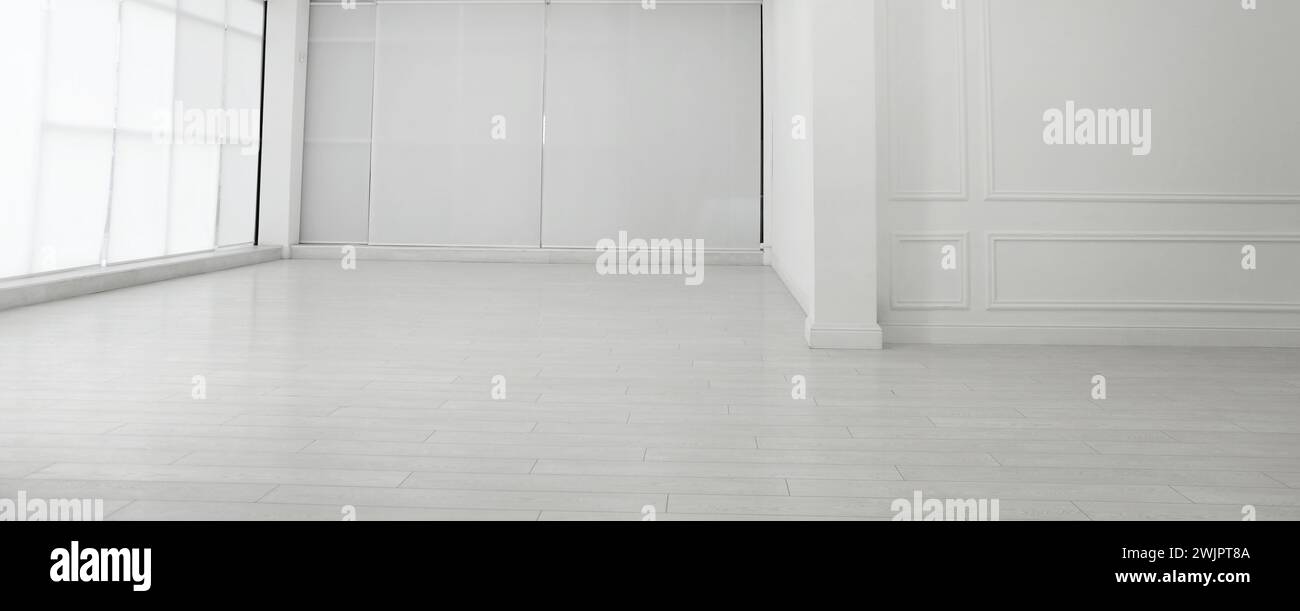 Empty room with white walls and laminated flooring Stock Photo