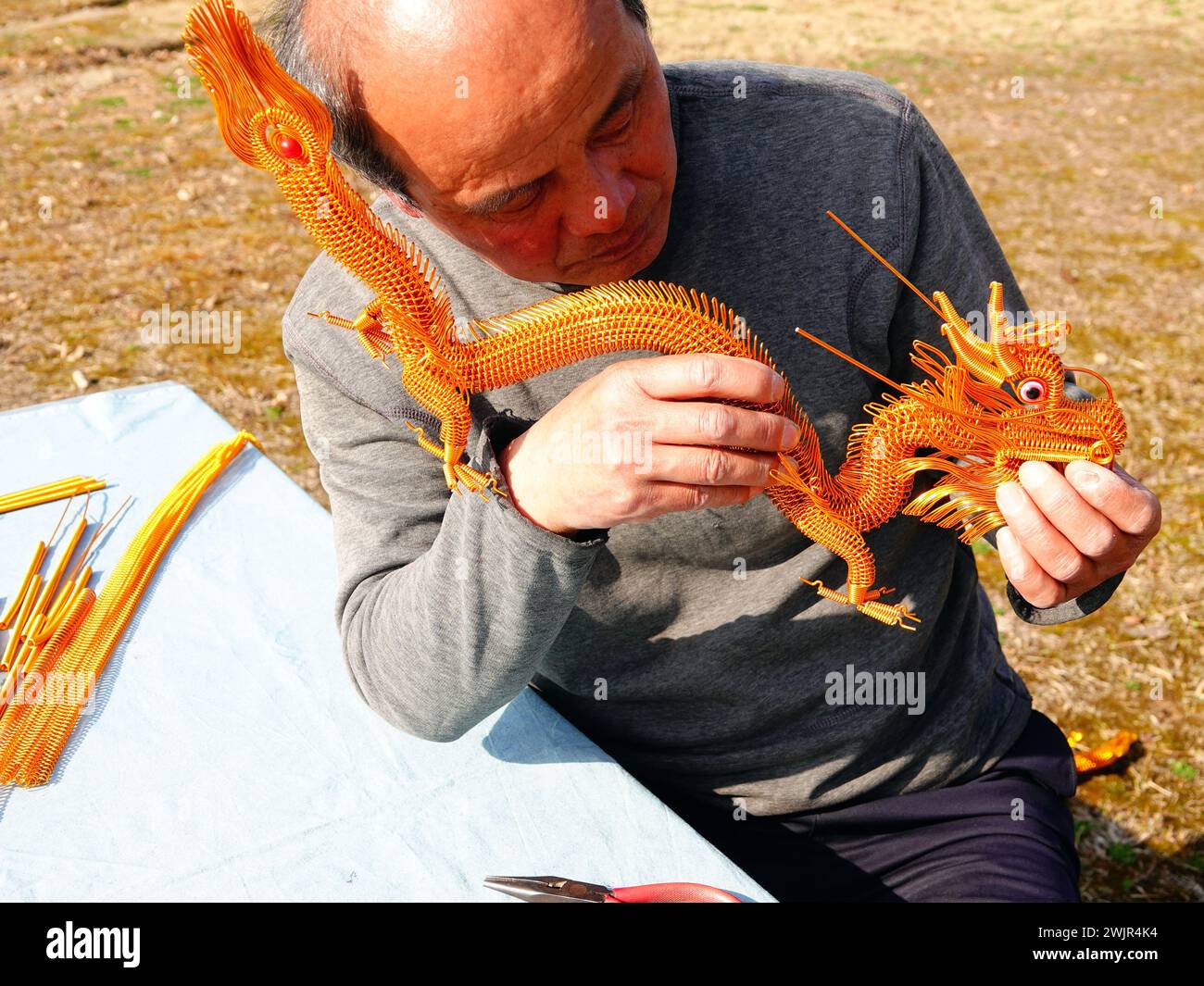 Folk artist Rong Zhongzhong creates and displays handicrafts such as an aluminum zodiac dragon to celebrate the Spring Festival of the Year of the Dra Stock Photo