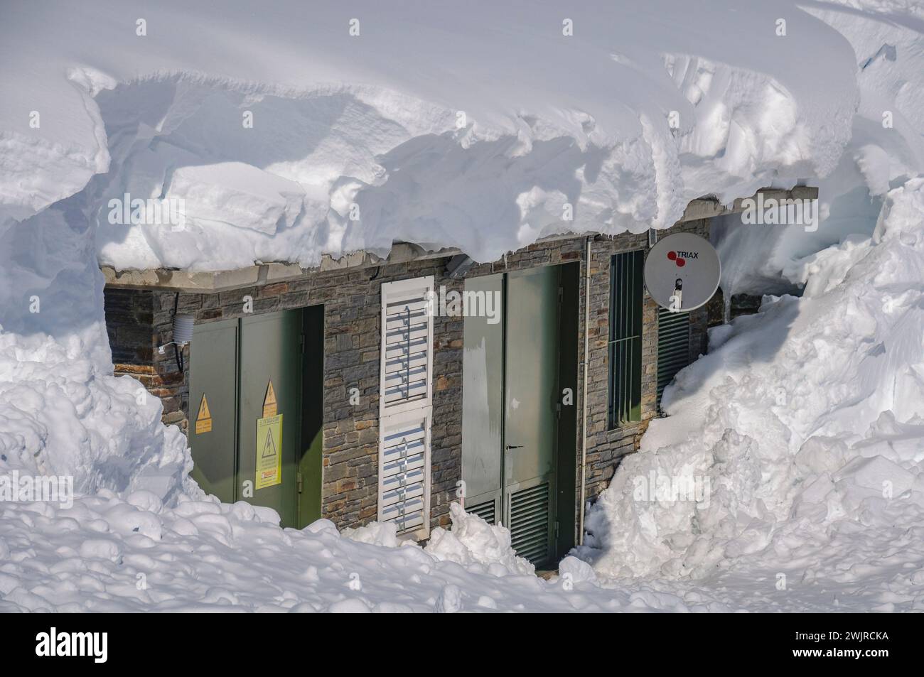 A building hanging in the snow after the heavy winter snowfalls of 2013 (Aran Valley, Lleida, Catalonia, Spain, Pyrenees) Stock Photo
