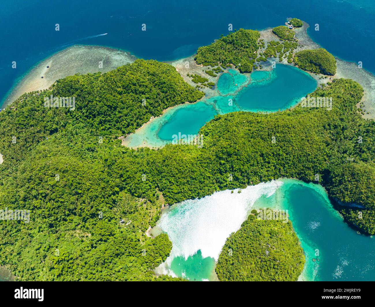 Beautiful sunlight reflected on the azure water. Turquoise lagoon and beach in tropical island. Tinago Island. Mindanao, Philippines. Stock Photo