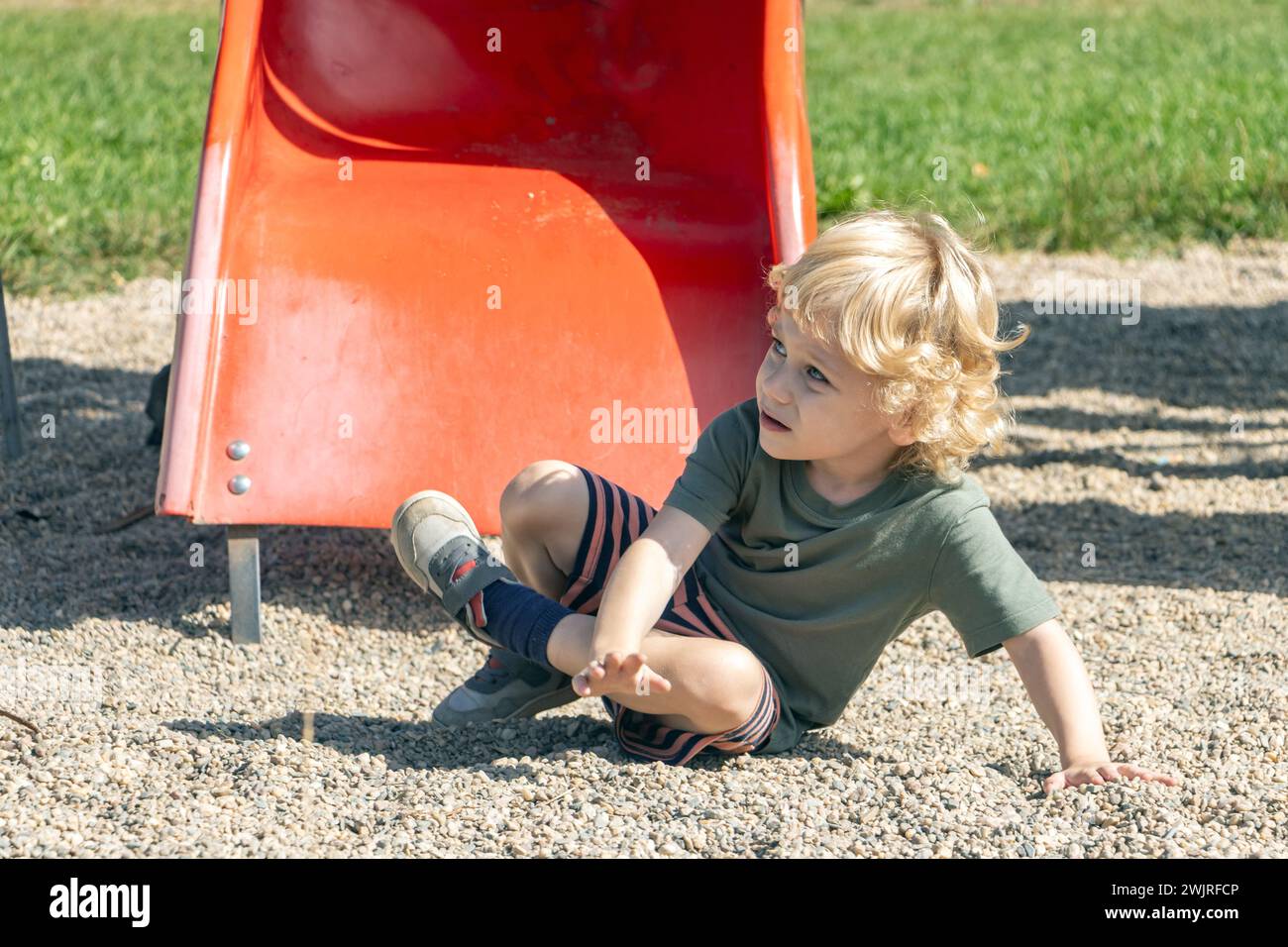 A little boy fell down from a slide Stock Photo
