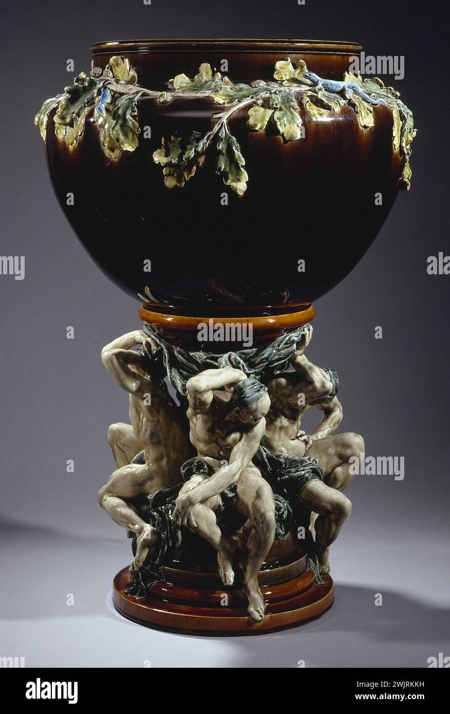 Carrier-Belleuse (Albert-Ernest Carrier de Belleuse, 1824-1887) and Auguste Rodin (1840-1917). 'Titans vase: Overview of the pot holder decorated with branches of oak leaves and lizard and its base decorated with four Atlanteans, in enameled ceramic, last quarter of the 19th century'. Ceramics and enamel, Manufacture de Choisy-le-Roi. Museum of Fine Arts of the City of Paris, Petit Palais. 26363-14 Atlante, branch, pot, ceramic emaillee, decor, email, chene leaf, lezard, choisy-le-roi manufacture, black, decorative object, base, vase of titans, 19th XIX 19th 19th 19th 19th century, mythology Stock Photo