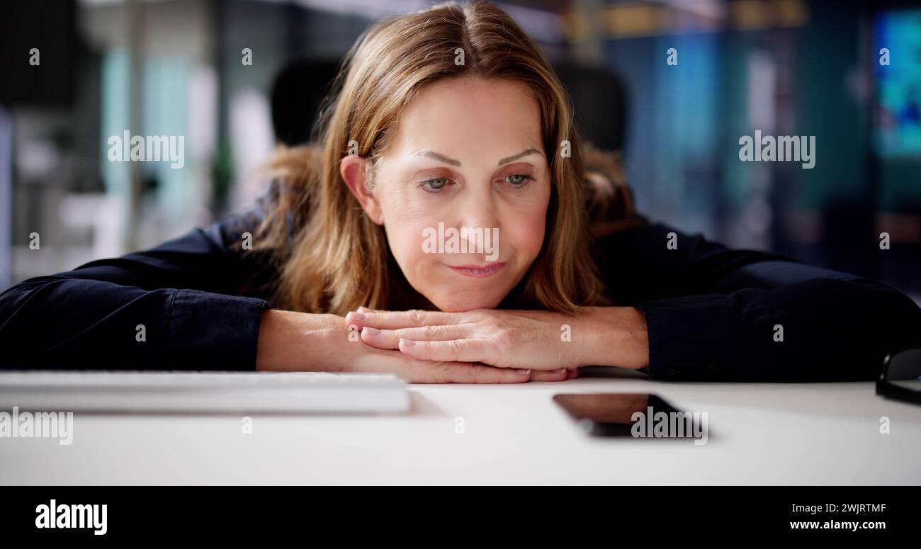 Woman Waiting Phone Call At Office Desk Stock Photo