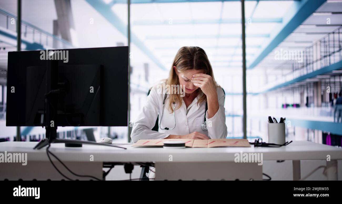 Upset Doctor Woman Holding Cardboard With Help Text In Office Stock Photo