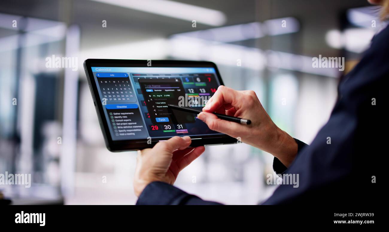 Executive Using Digital Calendar Agenda On Tablet Stock Photo