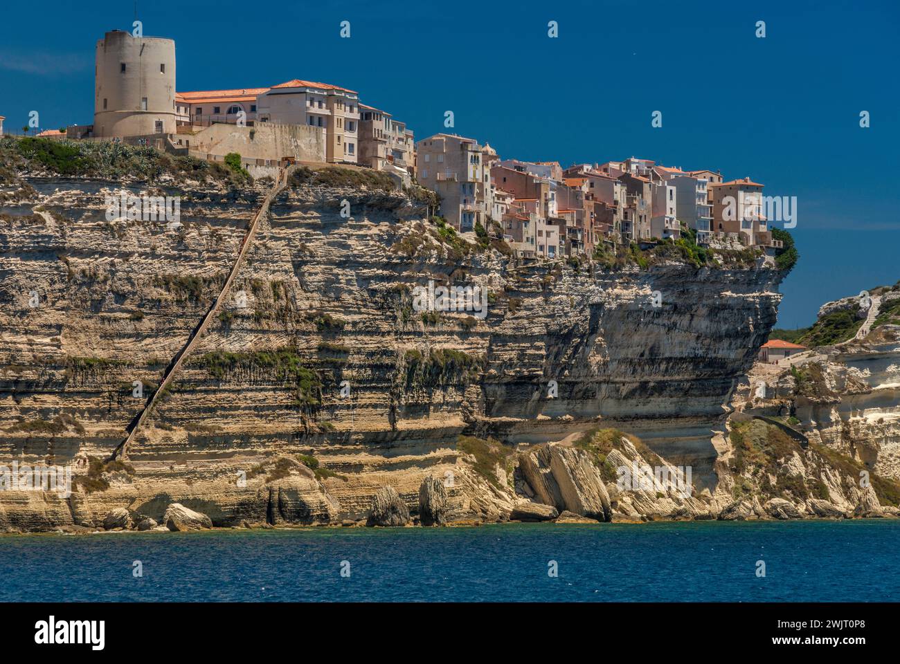 Citadelle on top of limestone cliffs, seen from the sea, King Aragon Steps on left, in Bonifacio, Corse-du-Sud, Corsica, France Stock Photo