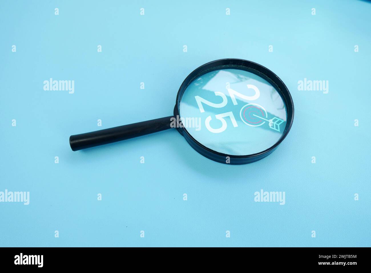Magnifying glass and targets 2025. Concept of new year 2025, beginning of success, challenge or career path, change, planning, goals, challenges and n Stock Photo