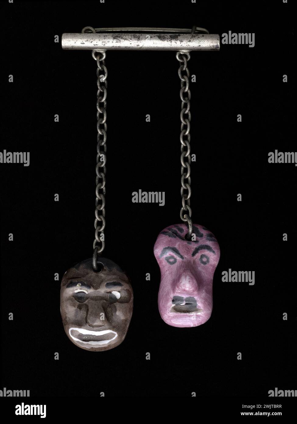 René Mittler. Pin 'Hitler and black', made up of a metallic pin to which two chains each carrying a ceramic mask, representing the face of a black man, and, no doubt, that of Adolf Hitler, 1940-1944 . Galliera, fashion museum of the city of Paris. The 2 faces represented on this pin are those of a black man and an Adolphe Hitler caricature. Accessory, jewelry, spindle, female, German state man, Nazism, black, Nazi Stock Photo