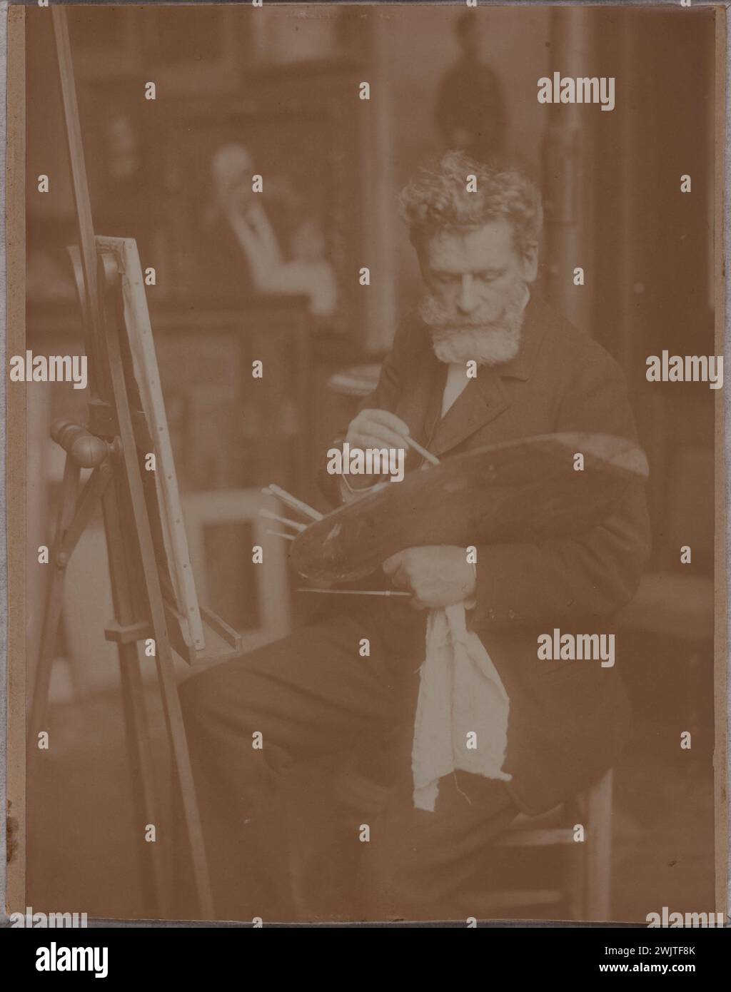 Anonymous. 'Alfred Roll painting in his workshop'. Draw on albumin paper, late 19th-early 20th century. Museum of Fine Arts of the City of Paris, Petit Palais. 71439-10 Workshop, easel, palette, albumin paper, paint, French painter, brush, draw Stock Photo