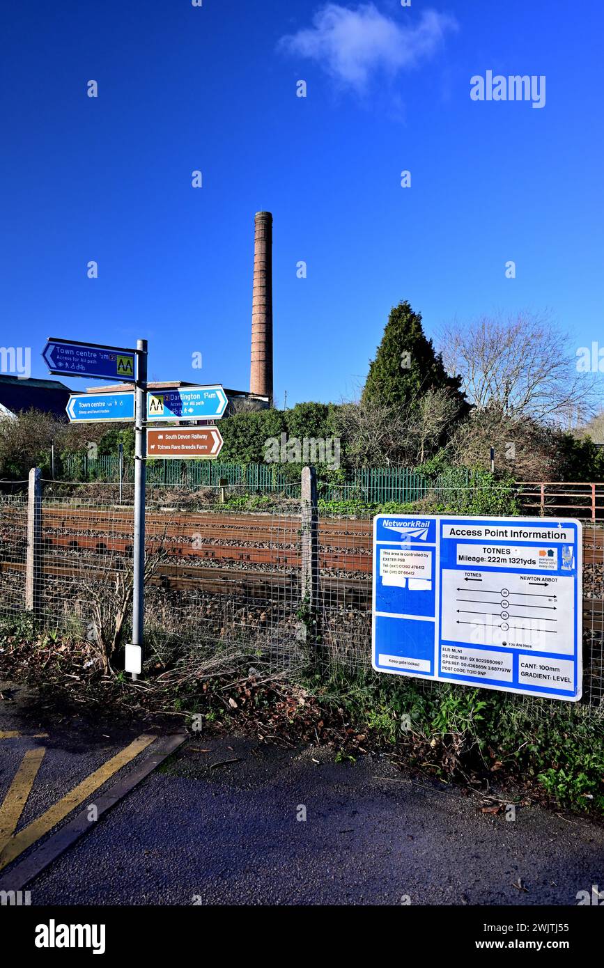 Signs at Totnes railway station and the chimney of the disused Dairy Crest factory. Stock Photo