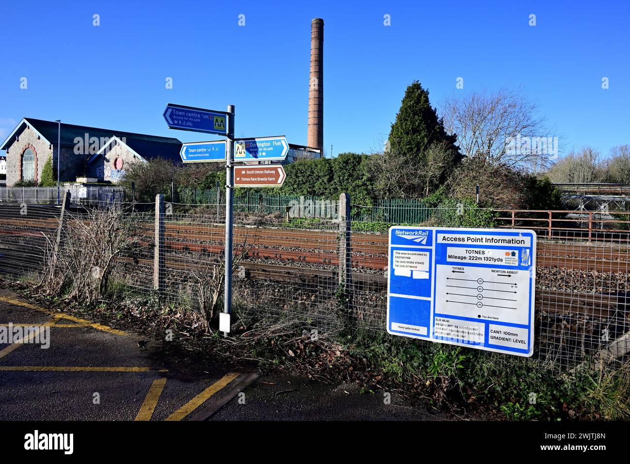 Signs at Totnes railway station and the chimney of the disused Dairy Crest factory. Stock Photo