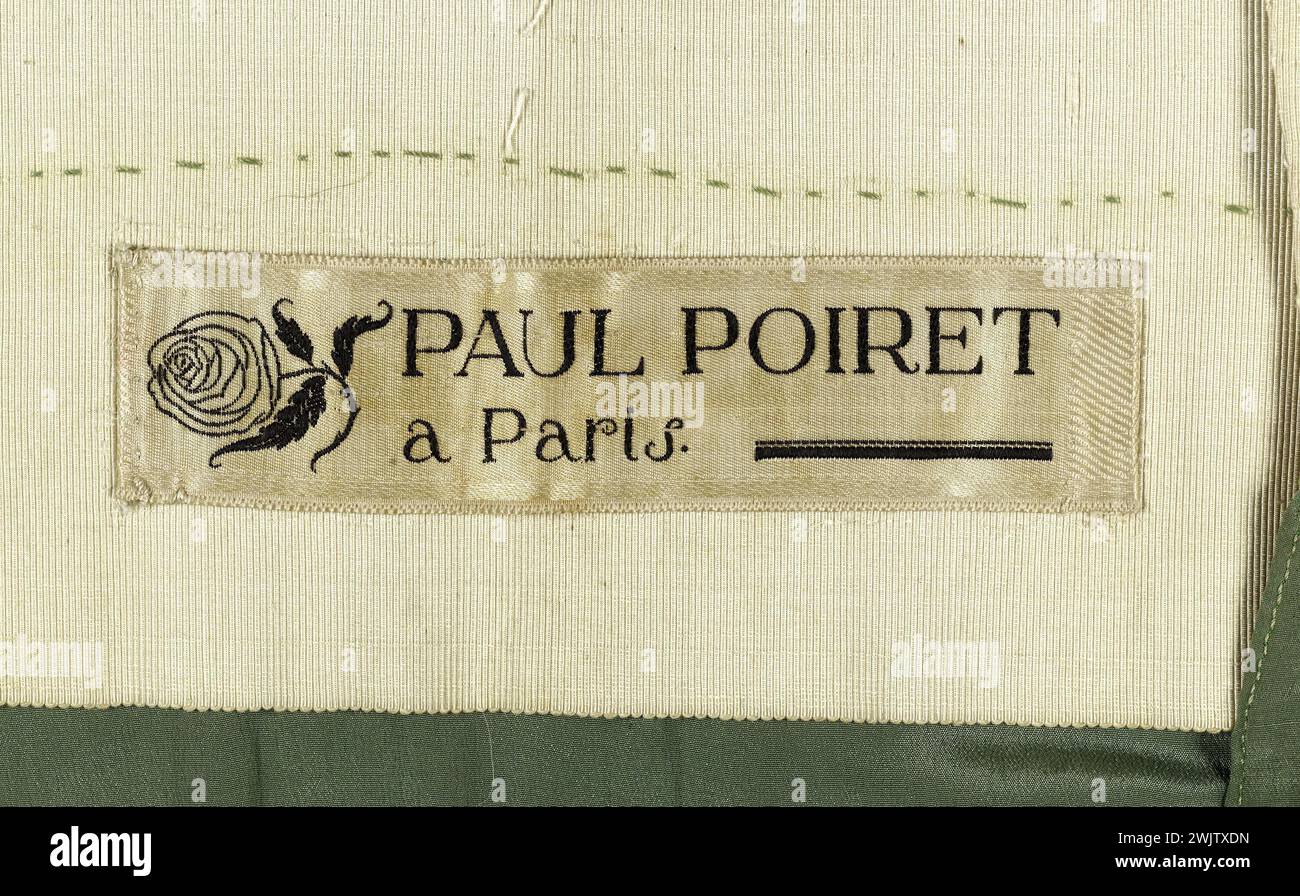 Paul Poiret. Evening gown. Tunic in brown and green cotton lampas and gilded metal spun, satin background and chroned patterns. Green silk skirt and green silk muslin. 1919-1921. Galliera, fashion museum of the city of Paris. 54690-16 Brown cotton, silk crepe, gold metal line, satin background, skirt, lampas, female mode, serge motif, muslin, evening dress, green, green Stock Photo