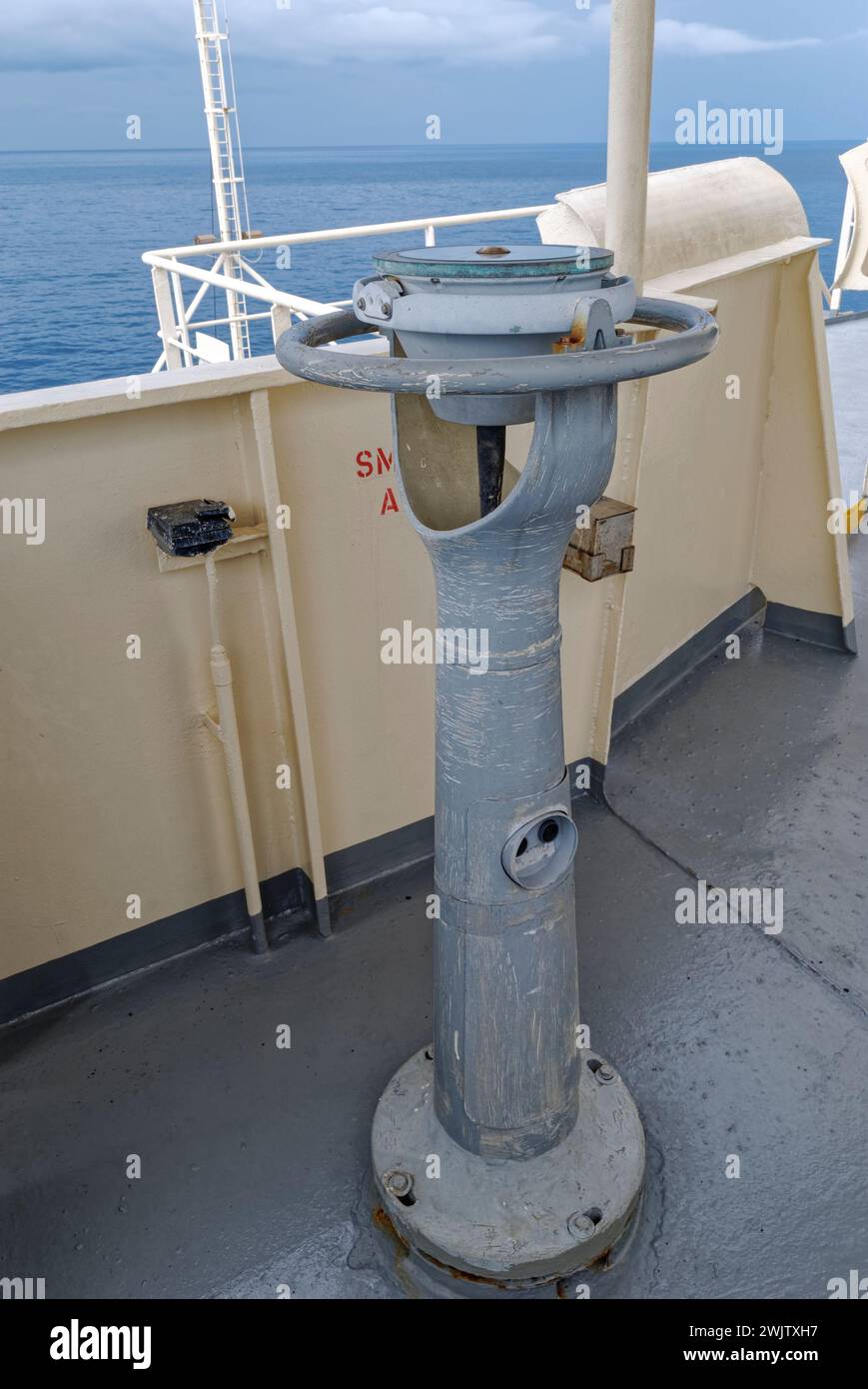 The external Ships Compass and sighting Pedestal of a Seismic Vessel on the Port side Bridge Wing, prepared for over painting. Stock Photo