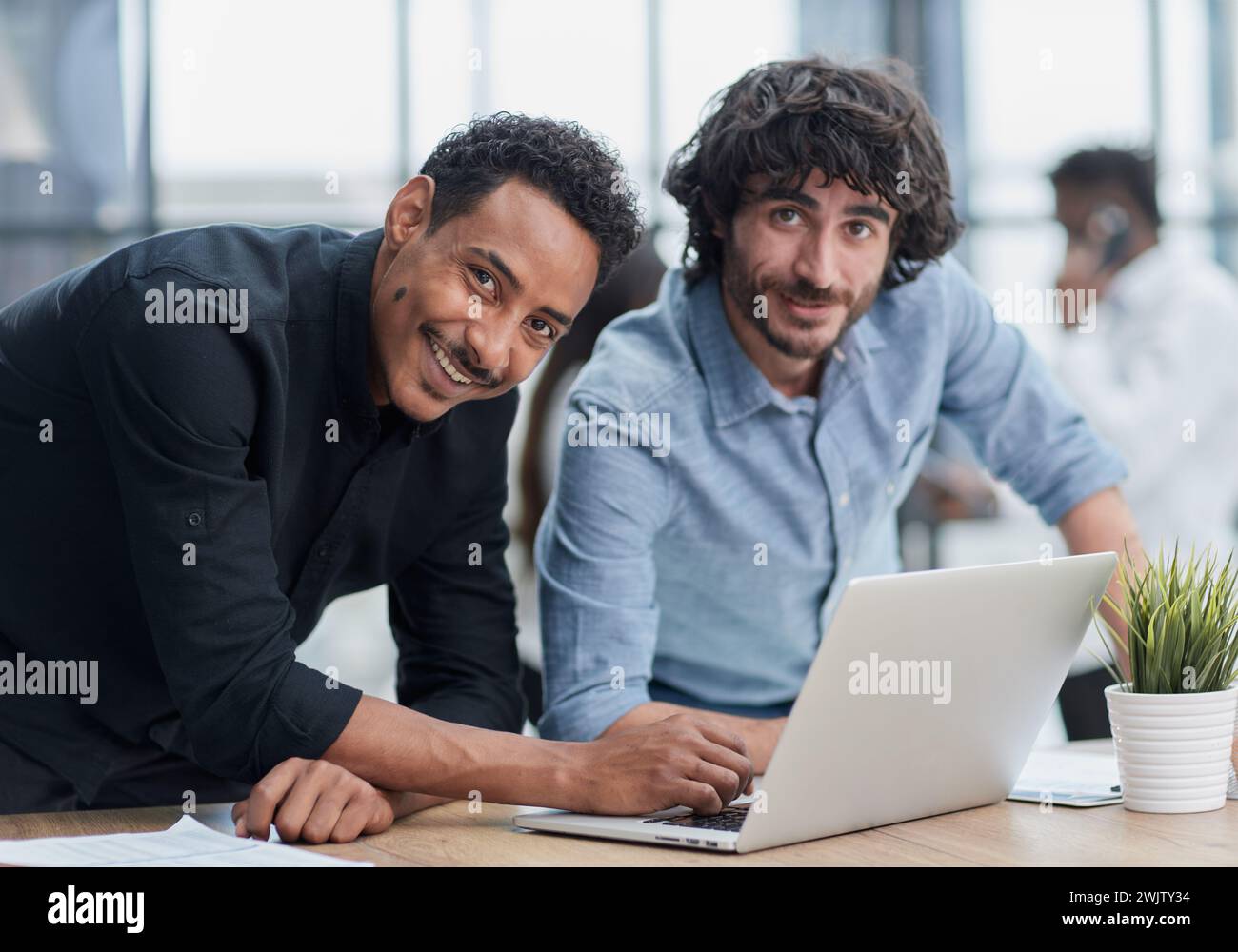 Business professionals collaborating happily in a modern office with ...
