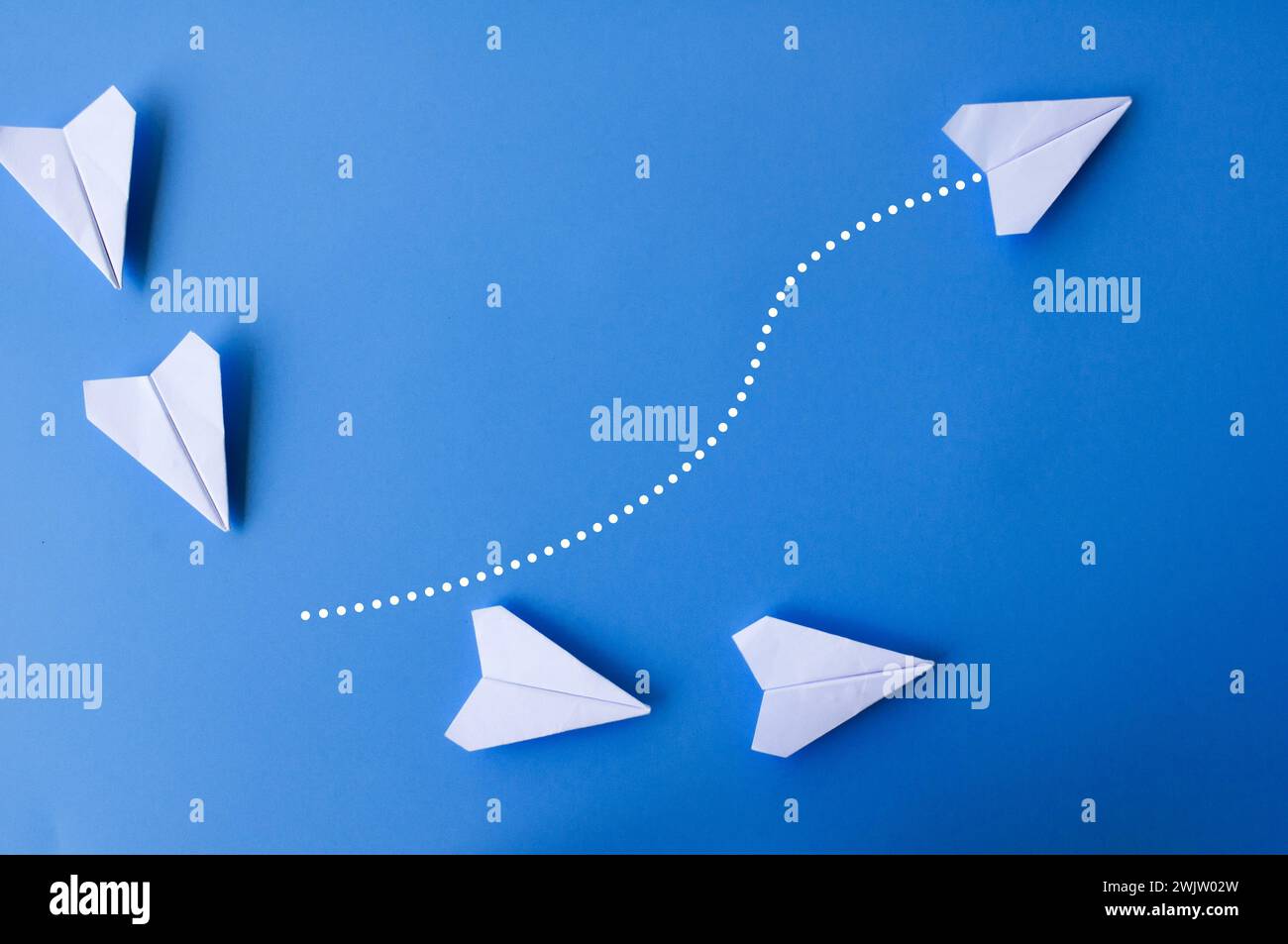 Top view of white paper airplanes with one flying at different direction Stock Photo