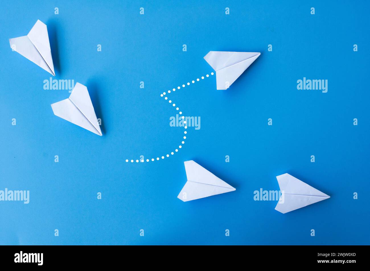 Top view of white paper airplanes origami with one flying at different direction Stock Photo