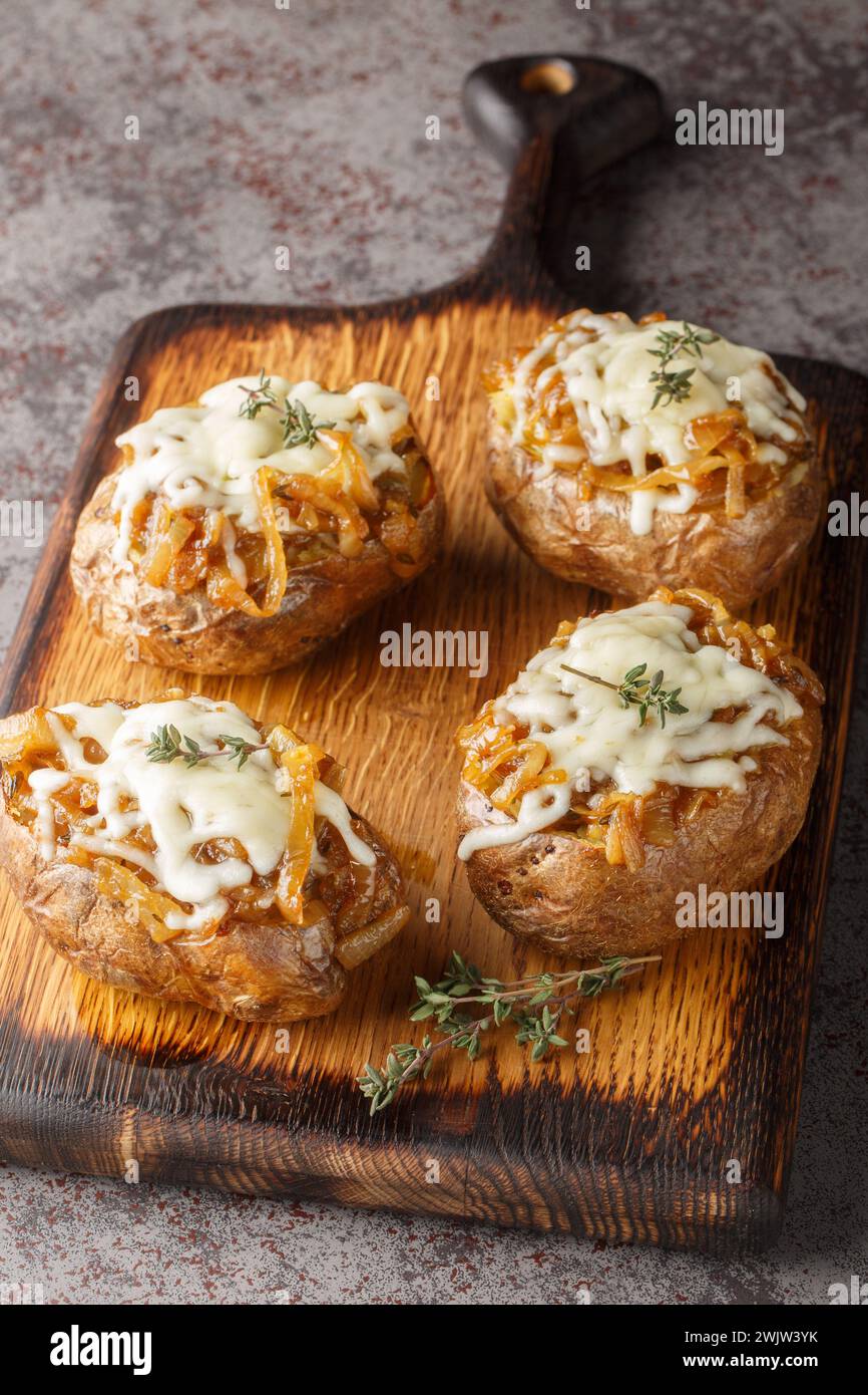 Cheesy French Onion Baked Potatoes closeup on the wooden board on the table. Vertical Stock Photo
